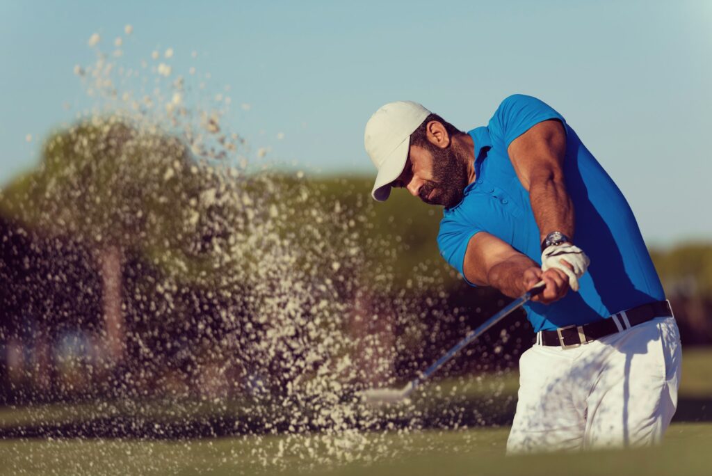 pro golfer hitting a sand bunker shot