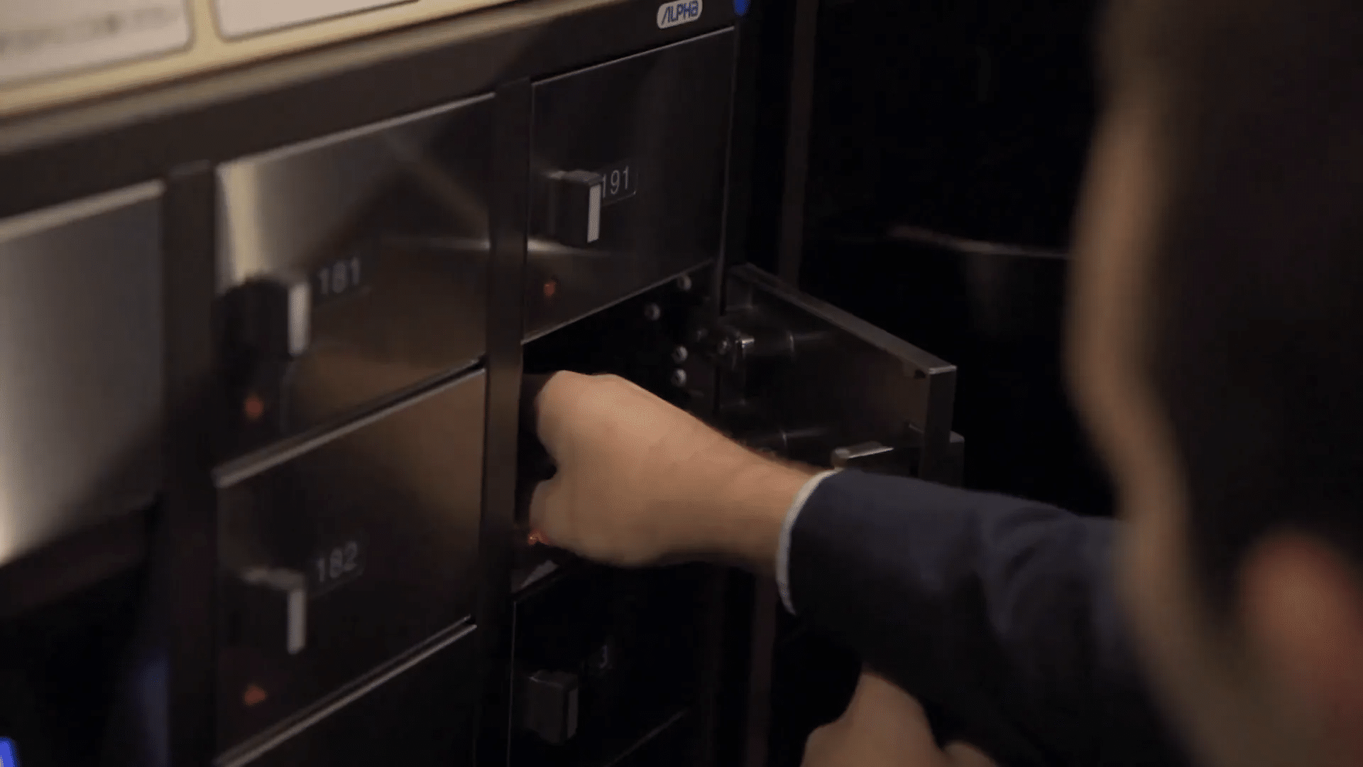 Sam legt seine Wertsachen in einem Safe-Deposit-Box im Clubhaus