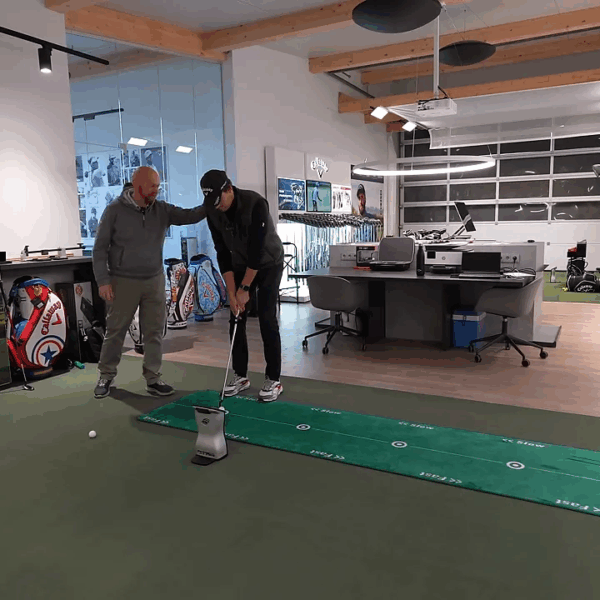 Fitter justiert die Körperhaltung des Spielers beim Putting‑Setup, Fokus auf Augenlinie und Ballposition