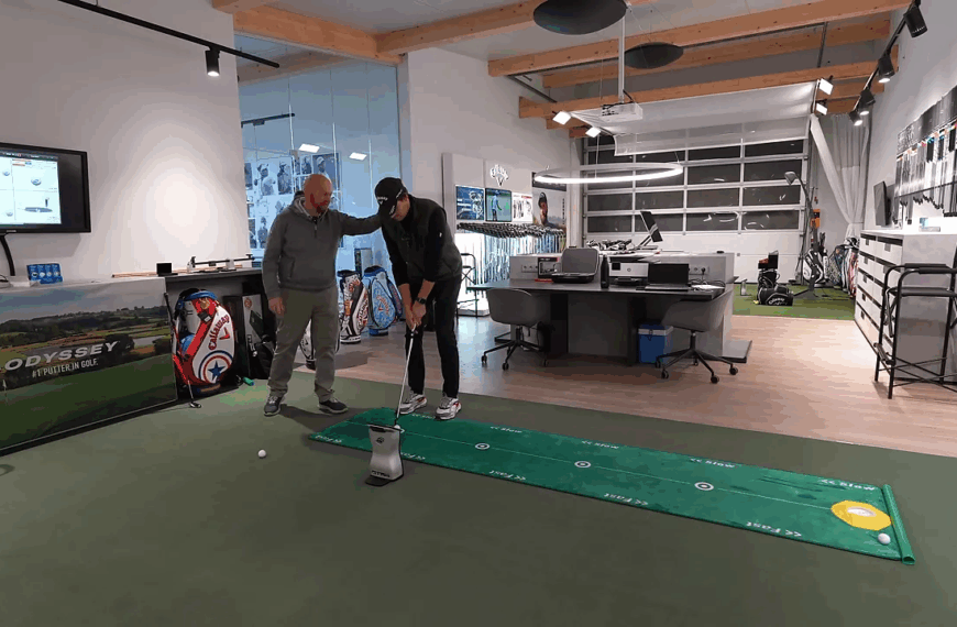 Fitter justiert die Körperhaltung des Spielers beim Putting‑Setup, Fokus auf Augenlinie und Ballposition