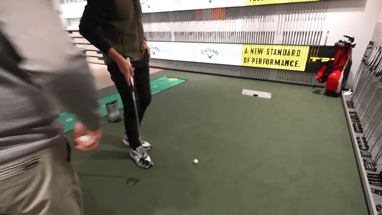 Putter Fitting: Schritt für Schritt zum stabileren Putt 8 Ball auf der Indoor‑Puttingfläche mit Spieler und Putter in Bereitschaft, Fokus auf Ausrichtung
