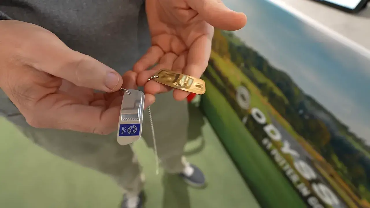 Putter Fitting: Schritt für Schritt zum stabileren Putt 4 Zwei Putter-Gewichte (silber und gold) in Händen, klare Detailaufnahme