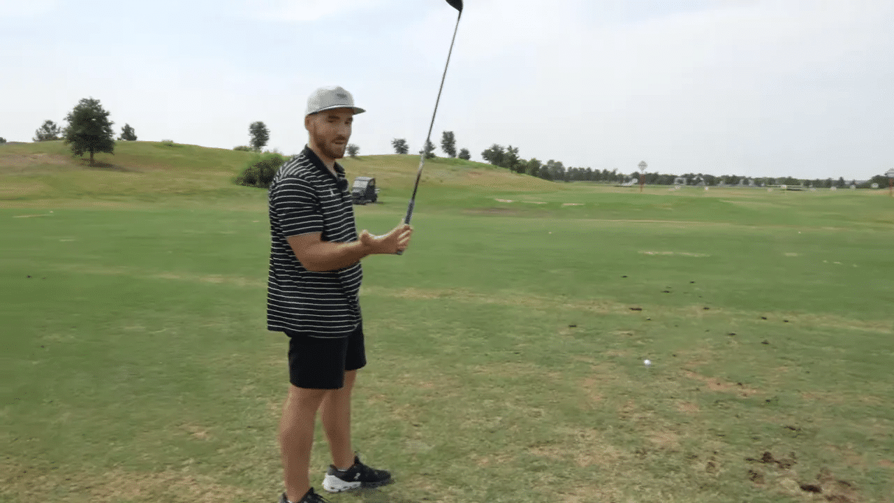 Golfer erklärt und demonstriert Driver-Haltung und Schwungvorbereitung auf der Driving Range