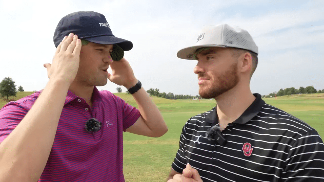 Zwei Golfer tragen Kohlblätter unter ihren Kappen und demonstrieren den Kühl-Hack auf der Driving Range; klare, ruhige Bildkomposition.