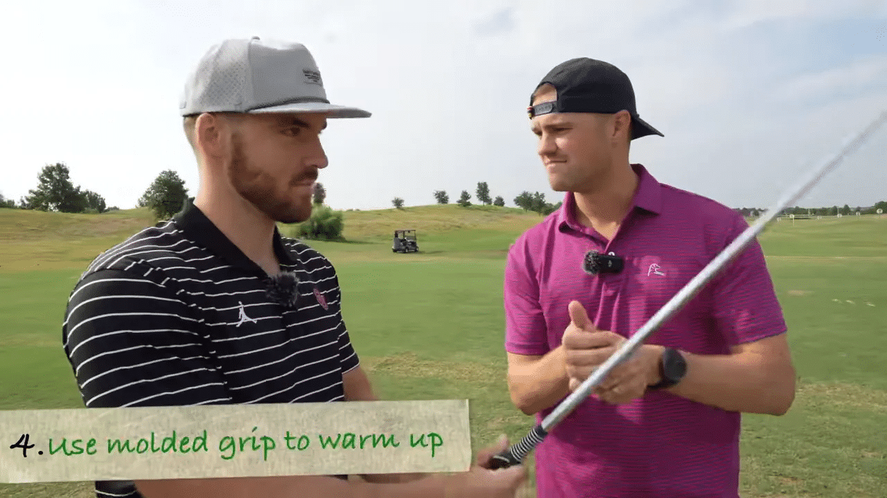 Trainer demonstriert geformten Griff am Golfschläger, zwei Golfer auf der Driving Range