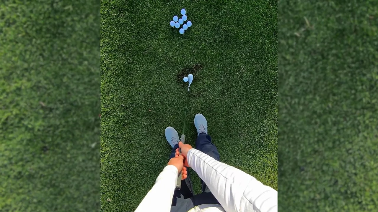 Vogelperspektive eines neutralen Golf-Setups beim Kurzspiel mit Schläger hinter dem Ball und Füßen zusammen