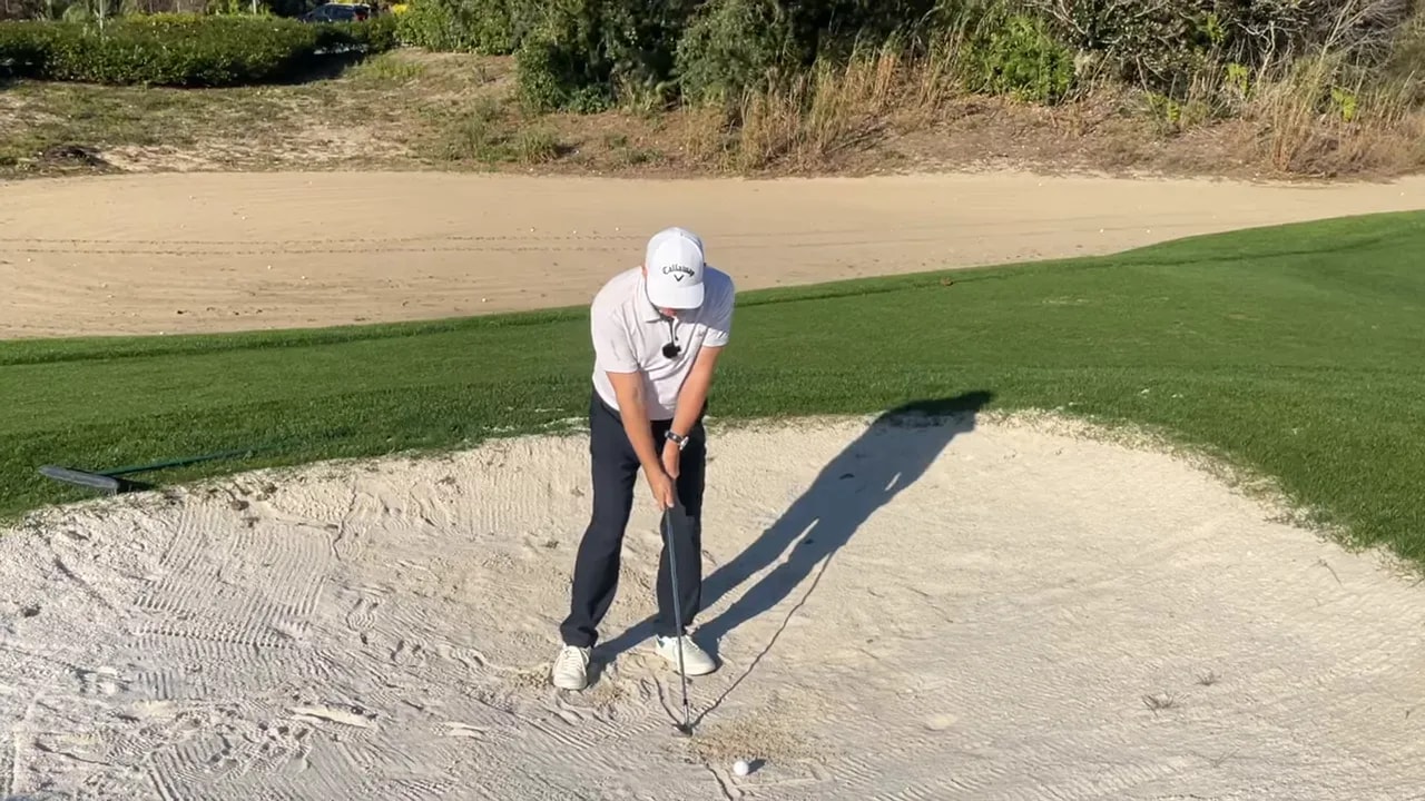 Golfer im Bunker beim Demonstrieren des stabilen Treffpunkts durch Rotation